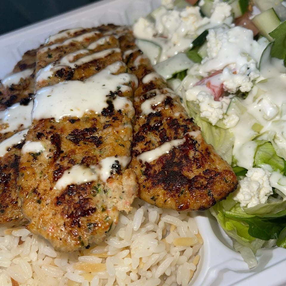 Black Seed Halal Grill's chicken kofta with white sauce, rice, and a side salad.